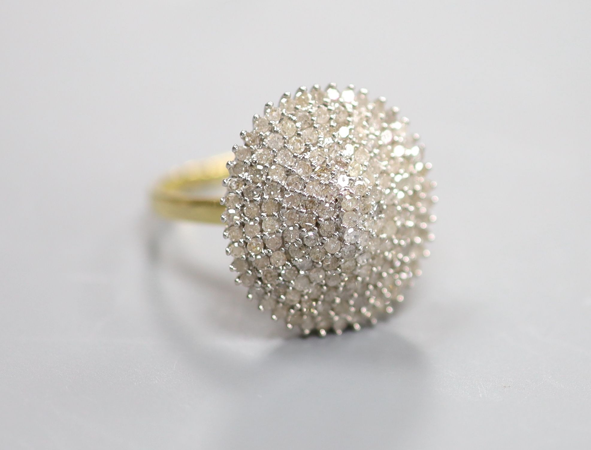 A modern 18kt and pave set diamond oval cluster dress ring, size P, gross weight 6.8 grams.